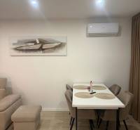 Dining room in a 3-room apartment with a wooden decor floor, table, and chairs.