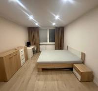 A bedroom in a 3-room apartment with a bed and furniture, floor with wooden decor.