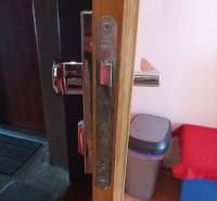 Detail of the door hardware and lock in a one-room apartment with a wooden decor floor.