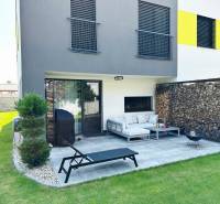 A family house in Rovinka with a terrace, garden, wooden cladding, and outdoor seating.