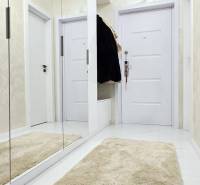 Hallway in a family house with white doors, a mirror, and a soft carpet.