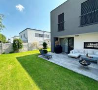 A family house in Rovinka with a terrace, green lawn, and outdoor seating.