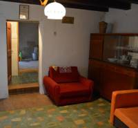 Living room in a family house with a red armchair and a cabinet with dishes.