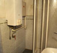 Shower enclosure with a gas boiler in the bathroom of a family house.