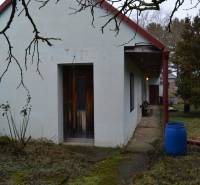 A family house in Abrahám with a courtyard, a blue barrel, and wooden doors.
