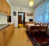 A kitchen in a 3-room apartment with a dining table, floor with wood decor.
