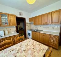 A kitchen with wooden cabinets and a dining table, suitable for a 3-room apartment.