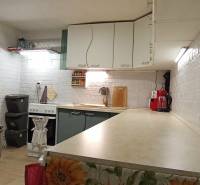A kitchen in a family house with white brick walls and kitchen appliances.