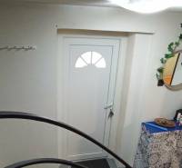 Entrance to a family house with white doors, a mirror, and decorative elements.