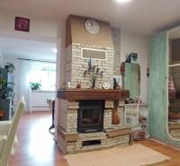 Interior of a family house with a fireplace and a wooden decor floor, complemented by colorful decorations.