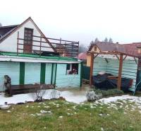Family house on Cintorínska in Divín with a shelter in the yard and a snow-covered lawn.