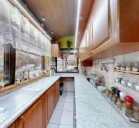 A kitchen in a family house with wooden cabinets and decorative spice jars.
