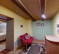 A room in a family house with a floor featuring a wooden decor, a sofa, and a small table.