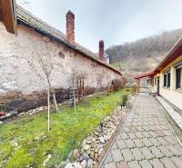 A family house on Hlavná Street in Hronský Beňadik with a paved walkway next to the lawn.