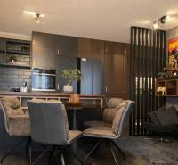 A kitchen in a 2-room apartment with dark cabinets and decorative posters on the wall.