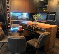 A kitchen in a 2-room apartment with black cabinets and a wood-patterned floor.