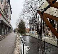 Commercial premises in Poprad next to glass railings and wet tiles, snowy sidewalk.