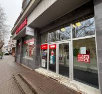 Commercial spaces in Poprad with large glass displays, featuring advertisements for discounts.