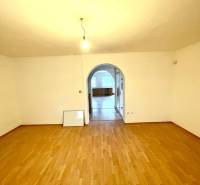 A room with an arched passage and a wooden decor floor in a family house.