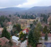 A wooded landscape with cottages in Modra surrounded by mountains and trees.
