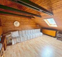 Attic room in a cottage with a wooden decor floor and a skylight.