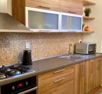 A kitchen with wooden decor and built-in appliances in a 3-room apartment.