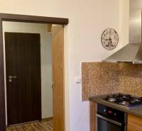 A kitchen in a 3-room apartment with a gas stove, mosaic tiles, and a floor with a wooden decor.