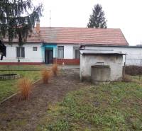 A family house in Kravany nad Dunajom with a grassy garden and a well on the property.