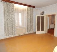A room in a family house with a wooden decor floor and curtains.