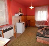 Interior of a family house with carpeted floor, pink walls, and a gas stove.