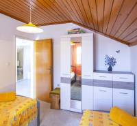 Bedroom in a Holiday Apartment with colorful bedding, a cabinet, and wall decorations.