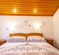 Bedroom in a Holiday Apartment with a bed and decorations on a white wall.