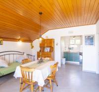 Recreational apartment with wood-decor flooring, dining table, and kitchen.