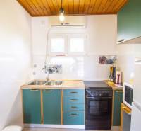 The kitchen in the holiday apartment with green cabinets, a stove, and decorative tiles.