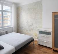 A bedroom in a 2-room apartment with wooden decor and an original wall.