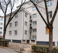 Apartment building in Bratislava at Jurajov Dvor, Pri starej prachárni. Four-story building, trees, sidewalk.