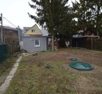 Garden cottage in Bratislava - Ružinov, Studená Street, surrounded by trees and fencing.