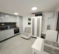 A kitchen in a cottage, with a dining table and gray kitchen cabinets.