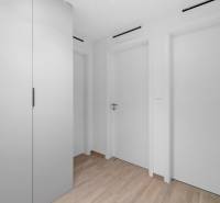 A hallway in a 2-room apartment with a built-in wardrobe and a floor with a wooden decor.
