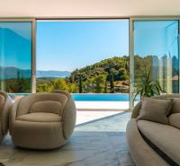 Living room in a villa with a view of the pool and nature.