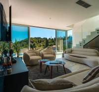 Living room of the villa with large windows, comfortable seating, and a view of nature.