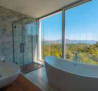 Luxury bathroom in a villa with a view of the sea and nature, floor with wooden decor.