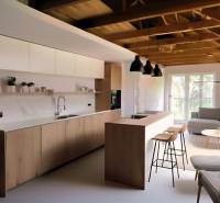 Interior of a family house with a wooden decor floor, kitchen, and living area.