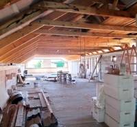 Attic with wooden beams and building materials, in a family house under construction.