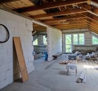 Construction of a family house with open space, building materials, and tools.