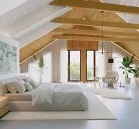 A bedroom in a family house with a wooden decor floor, beams, and a fireplace.
