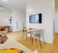 Living room in a studio apartment with wood-patterned flooring, a work corner, seating area.