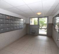 Lobby of an apartment building with mailboxes and glass doors.