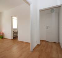 Interior of a 1-room apartment, white walls, floor with wood decor, built-in wardrobe.