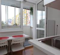 Kitchen in a studio apartment with a view and a balcony, floor with wood decor.